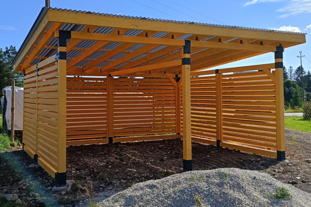 Large timber structure enclosed by horizontal slatted privacy walls.