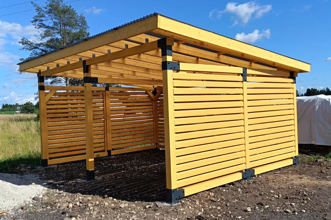 Freestanding timber carport with slatted walls on a prepared site.